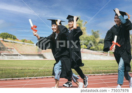 happy graduation students  holding diploma running 75037976
