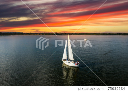 Yacht sailing at sunset during a storm. Luxury vacation at sea 75039284
