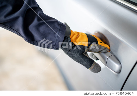Auto mechanic hand with glove holding car door handle 75040404
