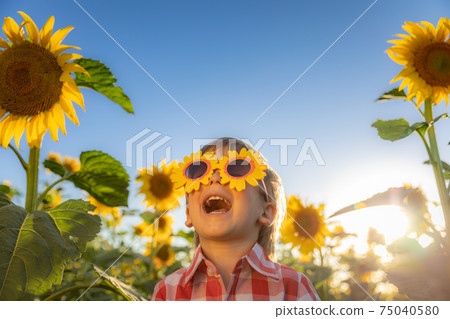 Happy child playing outdoor in spring field Happy child playing outdoor in spring field 75040580
