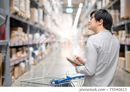 Asian man doing stocktaking on tablet in warehouse Asian man doing stocktaking on tablet in warehouse 75040615