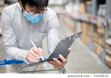 Asian man worker doing stocktaking in warehouse Asian man worker doing stocktaking in warehouse 75040616