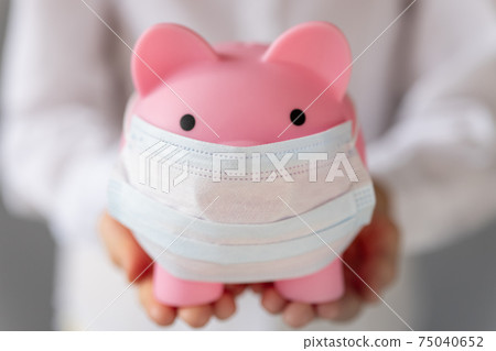 Piggybank wearing medical mask in children`s hands Piggybank wearing medical mask in children`s hands 75040652