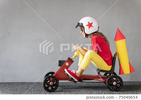 Funny kid driving racing car Funny kid driving racing car 75040654