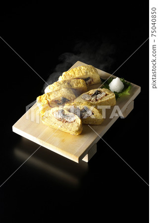 Photographed hot eel rolls served on sushi clogs on a black background Photographed hot eel rolls served on sushi clogs on a black background 75040850