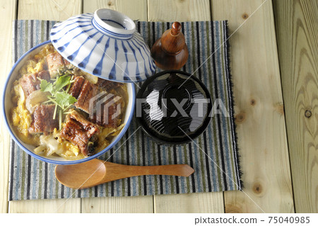 鳥瞰圖，有一個熱鰻魚碗，上面有鰻魚燒，放在餐桌墊，一套湯和一把木勺上 75040985