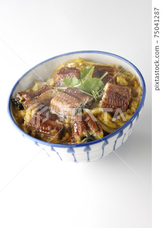 一個熱的鰻魚碗,用鰻魚鐮刀裝滿雞蛋在白色背景上 一個熱的鰻魚碗,用鰻魚鐮刀裝滿雞蛋在白色背景上 75041287