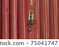 Red metal door closed on the lock corrugated steel fence gate padlock garage shed in Sofia, Bulgaria, Eastern Europe 75041747