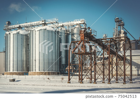 Grain elevator bins next to railroad during winter season Grain elevator bins next to railroad during winter season 75042513