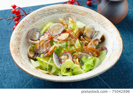 Steamed spring cabbage and clams, served with red pepper. Steamed spring cabbage and clams, served with red pepper. 75042896