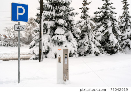 Modern electric car charging station after heavy snowfall 75042919