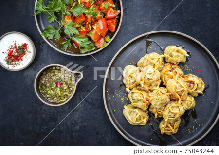 Traditional Kazakh manti steamed with mincemeat and tomato salad  75043244