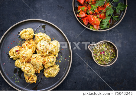 Traditional Kazakh manti steamed with mincemeat and tomato salad  75043245