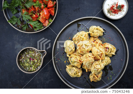 Traditional Kazakh manti steamed with mincemeat and tomato salad  75043246