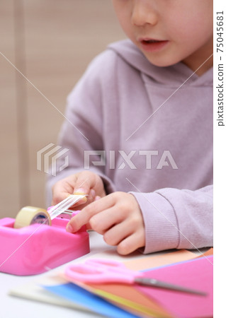 Girl who cuts and works on cellophane tape 75045681