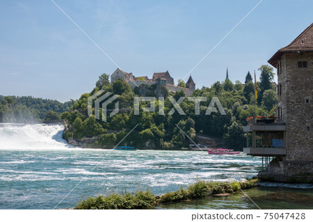Boat with people floating to the waterfall the Rhine Falls 75047428