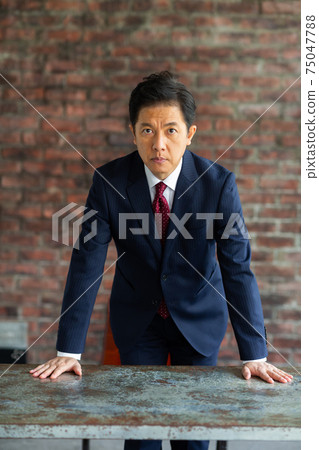 A man in a suit with an angry look A man in a suit with an angry look 75047788