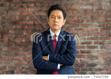A man in a suit with an angry look A man in a suit with an angry look 75047790