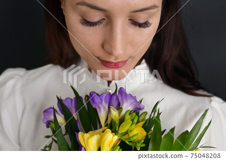 Young Woman and Bouquet Of Freesia Flowers 75048208