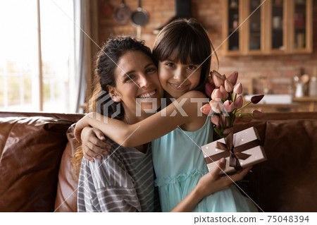 Portrait of happy Latino mom and daughter hugging 75048394