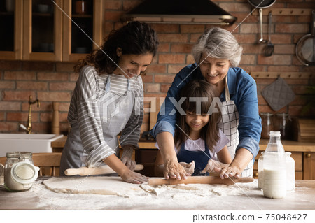 Happy three generations of women bake together Happy three generations of women bake together 75048427
