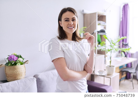 Portrait of happy smiling young woman looking at the camera in home 75048739