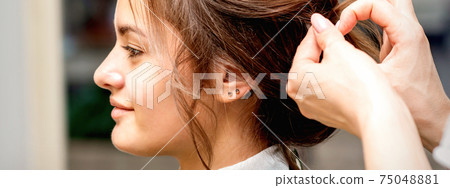 Hairstylist styling hair of woman Hairstylist styling hair of woman 75048881
