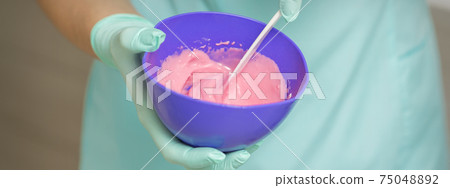 Hands prepares pink alginate mask Hands prepares pink alginate mask 75048892