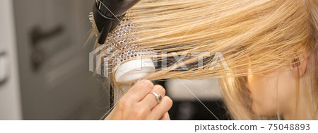 Hand drying hair of woman 75048893