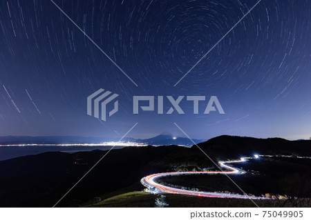 (Shizuoka Prefecture) Tracks of cars running on the Nishi-Izu Skyline, starry sky, distant view of Mt. Fuji 75049905