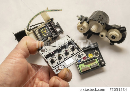 disassembled color inkjet printer printhead mechanism with pump and electronic control board in the engineer hand 75051384