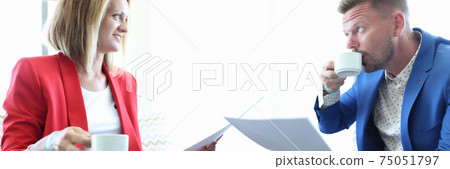 Man and woman are drinking coffee and studying documents Man and woman are drinking coffee and studying documents 75051797