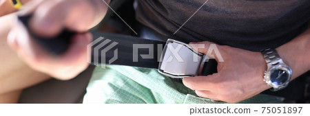 Man fastens his seat belt on an airplane. Man fastens his seat belt on an airplane. 75051897