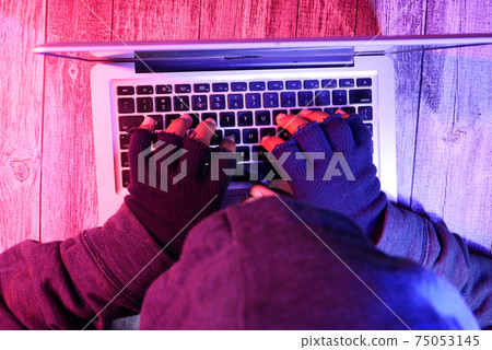 hacker hand stealing data from laptop top down hacker hand stealing data from laptop top down 75053145