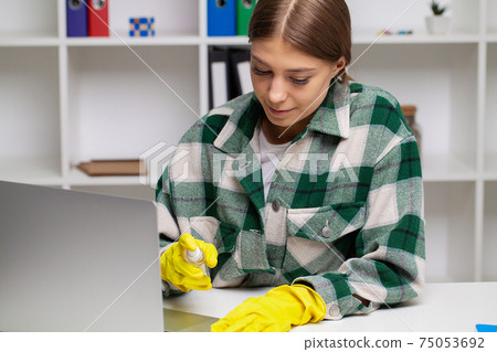 Woman in uniform with supplies cleaning in office Woman in uniform with supplies cleaning in office 75053692