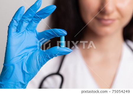 Closeup of female doctor holding pill for men health 75054249