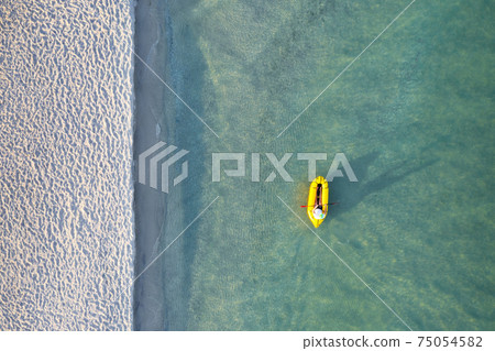 Yellow packraft rubber boat and turquoise water 75054582