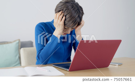 一個沮喪的看著電腦的女人 75057661