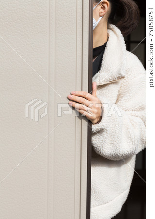 A woman who opens and closes a shutter A woman who opens and closes a shutter 75058751