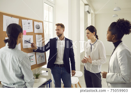 Business team analyzes sales graphs and charts, develops a new strategy, discussing work issues. 75059903