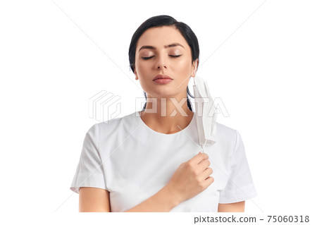 Attractive woman taking off medical mask for deep breath Attractive woman taking off medical mask for deep breath 75060318