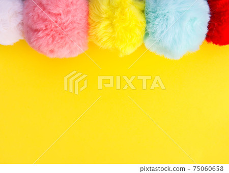 Colorful fluffy pompons on bright background. Fashion decoration festive template. Colorful fluffy pompons on bright background. Fashion decoration festive template. 75060658