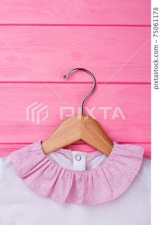 Kids garment on wooden hanger Kids garment on wooden hanger 75061178