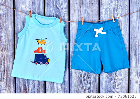 Baby boy clothes hanging on rope. 75061525