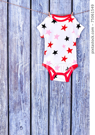 Infants cute bodysuit drying on rope. Infants cute bodysuit drying on rope. 75061549