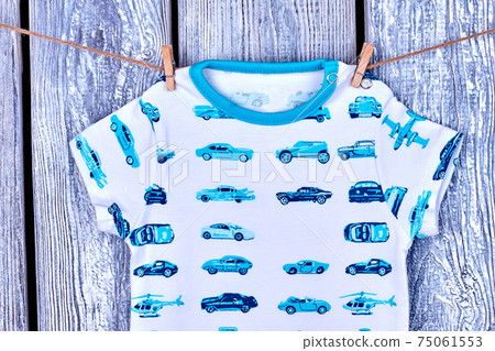 Baby boy t-shirt hanging on rope. 75061553