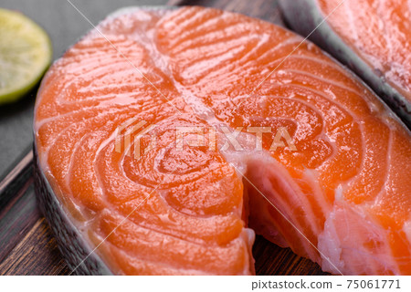 Fresh raw salmon steak with spices and herbs prepared for grilled baking 75061771
