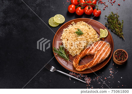 Fresh cooked delicious salmon steak with spices and herbs baked on a grill 75061800