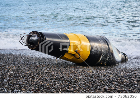 damaged sea buoy - cardinal danger mark - washed ashore after a storm damaged sea buoy - cardinal danger mark - washed ashore after a storm 75062056