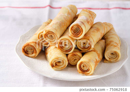 Crepes, thin pancakes with honey and tea on a white plate. 75062918